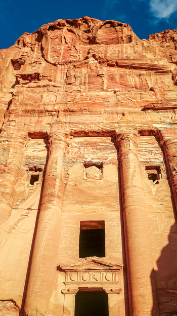 View of the iconic rock cut facade of Al Khazneh also known as the Treasury carved into the vibrant sandstone cliffs of the ancient city of Petra Wadi Musa Ma an Governorate Jordan. View of the iconic rock cut facade of Al Khazneh also known as the Treasury carved into the vibrant sandstone cliffs of the ancient city of Petra Wadi Musa Ma an Governorate Jordan.