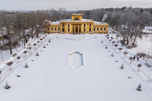 Aerial view of the yellow Traku Voke Manor and its snow covered courtyard surrounded by bare trees in winter Vilnius Vilniaus apskritis Lithuania.