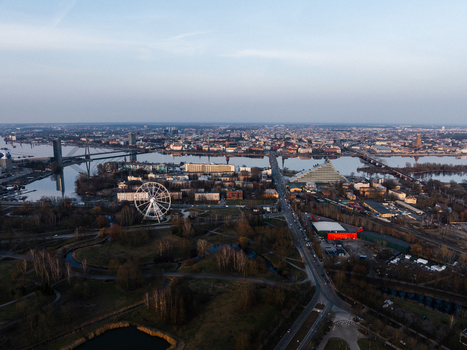 Aerial view of the Daugava River the National Library of Latvia and the ferris wheel with the historic Old Town skyline under a soft sunset sky in Riga Latvia. Aerial view of the Daugava River the National Library of Latvia and the ferris wheel with the historic Old Town skyline under a soft sunset sky in Riga Latvia.