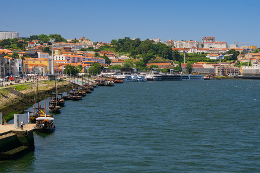 Aerial view of boats lining the Douro River near the Dom Luís I Bridge contrasting with the terracotta roofs and the city s skyline Porto Porto District Portugal. Aerial view of boats lining the Douro River near the Dom Luís I Bridge contrasting with the terracotta roofs and the city s skyline Porto Porto District Portugal.