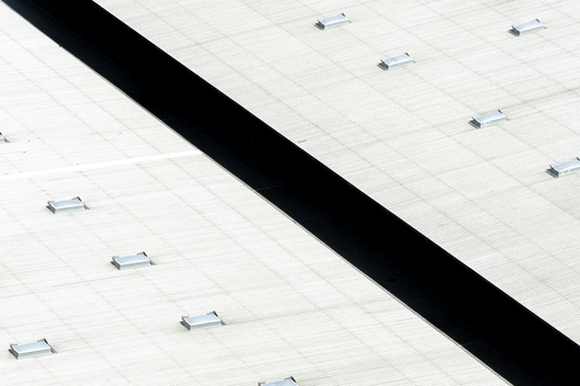 Aerial view of a warehouse roof featuring multiple skylights and a deep dark central trench Poland.