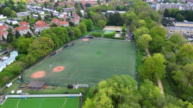 Aerial view of a green sports field and residential area Belgium.