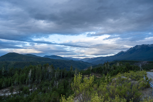 View of the mountainous landscape with dense forests and a dramatic cloudy sky in El Bolson Rio Negro Province Argentina. View of the mountainous landscape with dense forests and a dramatic cloudy sky in El Bolson Rio Negro Province Argentina.