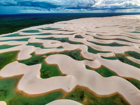 Aerial view of Lagoa Bonita featuring white sand dunes and turquoise lagoons under a dramatic cloudy sky in Barreirinhas Maranhao Brazil. Aerial view of Lagoa Bonita featuring white sand dunes and turquoise lagoons under a dramatic cloudy sky in Barreirinhas Maranhao Brazil.