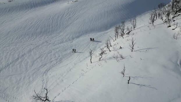 Aerial view of people hiking on a snowy slope Norway.