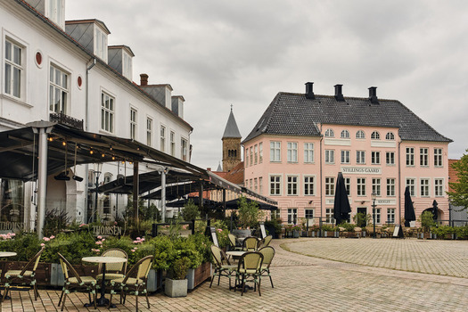 Viborg Denmark 07 August 2026 View of Nytorv square featuring historic buildings outdoor restaurant seating and a distant church tower under a cloudy sky. Viborg Denmark 07 August 2026 View of Nytorv square featuring historic buildings outdoor restaurant seating and a distant church tower under a cloudy sky.