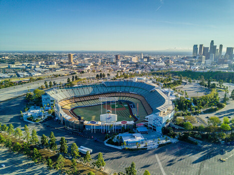 Los Angeles United States 04 February 2017 Aerial view of Dodger Stadium bathed in the warm glow of the setting sun silhouetted against the distant towering skyline.