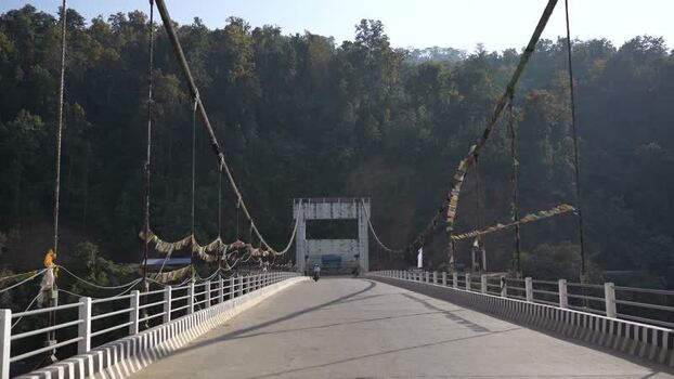 View of a suspension bridge with prayer flags in Surkhet Nepal.