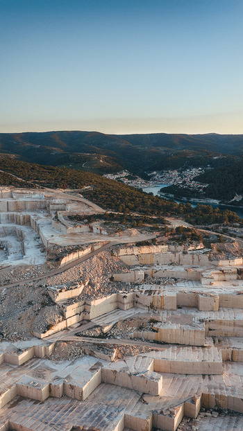 Aerial view of Jadrankamen white stone quarry with terraced excavations overlooking the coastal town and bay in Pucisca Splitsko dalmatinska Croatia. Aerial view of Jadrankamen white stone quarry with terraced excavations overlooking the coastal town and bay in Pucisca Splitsko dalmatinska Croatia.