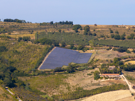 Aerial view of a solar panel farm situated in the rolling rural landscape of the Marche region surrounded by agricultural fields olive groves and farm buildings in Ortezzano Marche Italy. Aerial view of a solar panel farm situated in the rolling rural landscape of the Marche region surrounded by agricultural fields olive groves and farm buildings in Ortezzano Marche Italy.