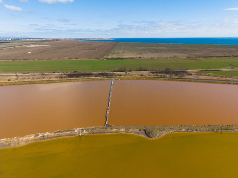 Aerial view of the colorful salt pans of Lake Atanasovsko with pink and yellow water sections divided by a dike near the Black Sea coast in Burgas Burgas Bulgaria. Aerial view of the colorful salt pans of Lake Atanasovsko with pink and yellow water sections divided by a dike near the Black Sea coast in Burgas Burgas Bulgaria.