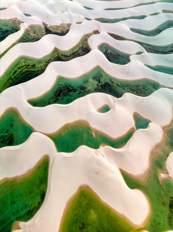 Aerial view of Lagoa Bonita featuring white sand dunes and vibrant green lagoons in the Lencois Maranhenses National Park in Barreirinhas State of Maranhao Brazil. Aerial view of Lagoa Bonita featuring white sand dunes and vibrant green lagoons in the Lencois Maranhenses National Park in Barreirinhas State of Maranhao Brazil.