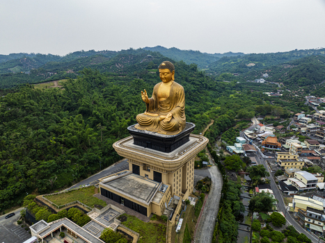 Aerial view of the giant golden Buddha statue overlooking lush green hills in Jiuru Township Pingtung County Taiwan. Aerial view of the giant golden Buddha statue overlooking lush green hills in Jiuru Township Pingtung County Taiwan.