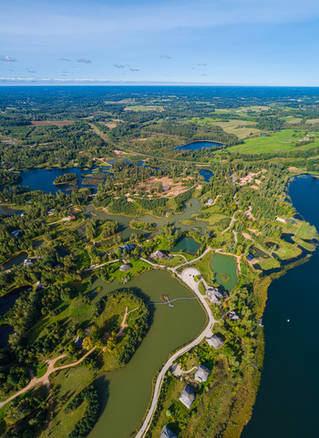 Aerial view of a landscape featuring multiple lakes ponds forests green fields and scattered houses in Latvia. Aerial view of a landscape featuring multiple lakes ponds forests green fields and scattered houses in Latvia.