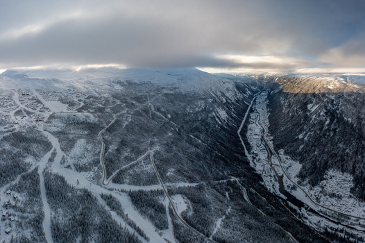 Aerial view of Gaustablikk Fjellresort surrounded by snow covered mountains ski slopes and winding roads in the valley of Rjukan Telemark Norway. Aerial view of Gaustablikk Fjellresort surrounded by snow covered mountains ski slopes and winding roads in the valley of Rjukan Telemark Norway.
