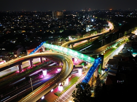 Aerial view of the illuminated Flyover Tapal Kuda Jakarta at night with vibrant pedestrian bridge lighting and traffic light trails in Pasar Minggu Daerah Khusus Ibukota Indonesia. Aerial view of the illuminated Flyover Tapal Kuda Jakarta at night with vibrant pedestrian bridge lighting and traffic light trails in Pasar Minggu Daerah Khusus Ibukota Indonesia.