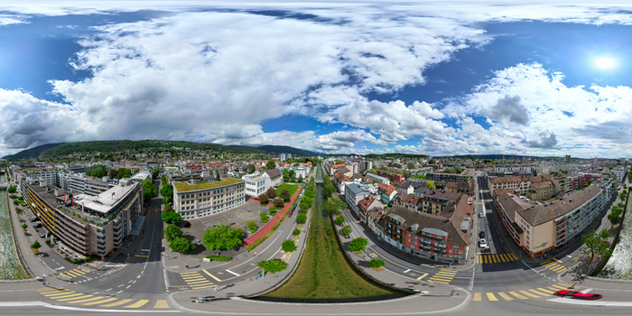 Aerial view of the urban landscape featuring a central canal historic and modern buildings and lush green hills under a bright cloudy sky in Biel Bienne Canton of Bern Switzerland. Aerial view of the urban landscape featuring a central canal historic and modern buildings and lush green hills under a bright cloudy sky in Biel Bienne Canton of Bern Switzerland.