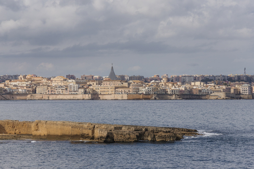 View of the historic skyline of Ortigia and the Sanctuary of Our Lady of Tears across the water Syracuse Sicily Italy.