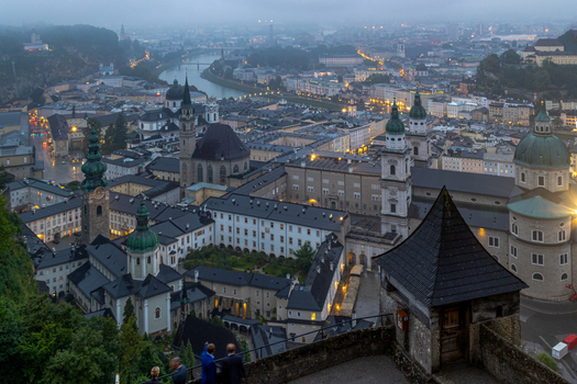 Aerial view of the historic Salzburg Cathedral and the surrounding old town rooftops with illuminated streets and the Salzach river in Salzburg Salzburg Austria. Aerial view of the historic Salzburg Cathedral and the surrounding old town rooftops with illuminated streets and the Salzach river in Salzburg Salzburg Austria.