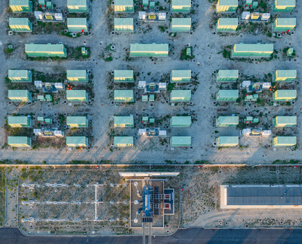 Aerial view of modular battery storage units arranged in a geometric grid showcasing modern energy infrastructure and industrial technology in Italy. Aerial view of modular battery storage units arranged in a geometric grid showcasing modern energy infrastructure and industrial technology in Italy.