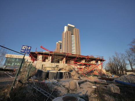 Riga Latvia 03 April 2025 View of Panorama Plaza residential towers rising above a construction site with red scaffolding and building materials under a clear blue sky. Riga Latvia 03 April 2025 View of Panorama Plaza residential towers rising above a construction site with red scaffolding and building materials under a clear blue sky.