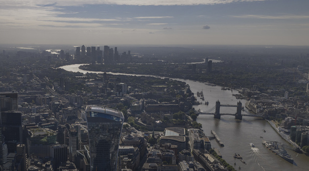 Aerial view of The Fenchurch Building Tower Bridge and the winding River Thames under a hazy sky London England United Kingdom. Aerial view of The Fenchurch Building Tower Bridge and the winding River Thames under a hazy sky London England United Kingdom.