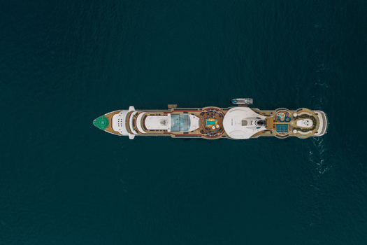 Aerial view of a large cruise ship sailing on the deep blue Mediterranean Sea with visible decks swimming pools and a helipad in Cannes Provence Alpes Cote d Azur France. Aerial view of a large cruise ship sailing on the deep blue Mediterranean Sea with visible decks swimming pools and a helipad in Cannes Provence Alpes Cote d Azur France.
