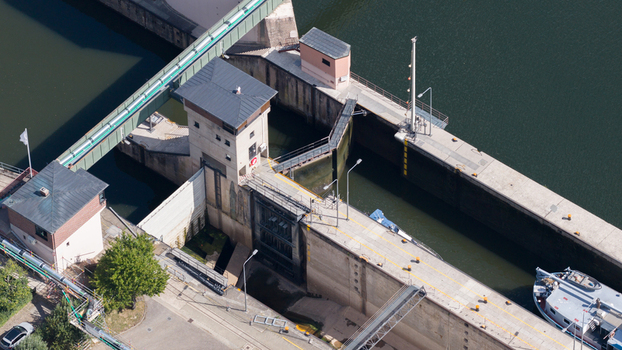 Aerial view of the Neckar Staustufe und Schleuse Rockenau showing concrete lock chambers control towers and a boat on the Neckar River in Eberbach Baden Wurttemberg Germany.