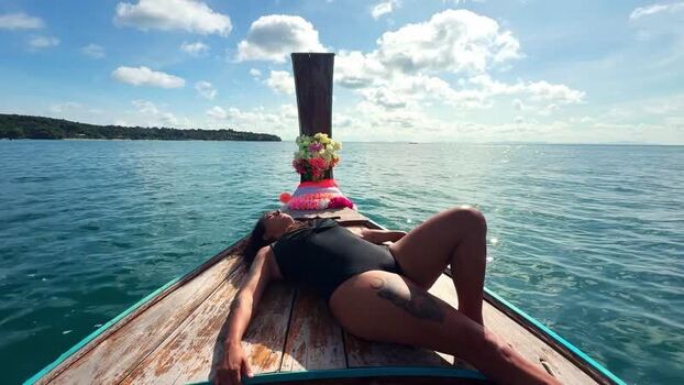 View of a woman relaxing on a longtail boat Thailand.