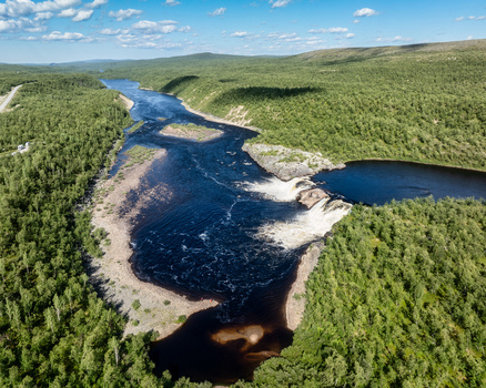 Aerial view of Pikefossen falls with its cascading water flowing through the lush green forests and rocky landscape of Kautokeino Finnmark Norway. Aerial view of Pikefossen falls with its cascading water flowing through the lush green forests and rocky landscape of Kautokeino Finnmark Norway.