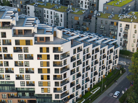 Aerial view of modern residential apartment buildings with white facades balconies and green roofs in an urban setting in Krakow Lesser Poland Voivode Poland.
