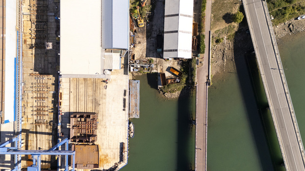 Aerial view of the industrial shipyard in Zumaia featuring metal structures large warehouses and a bridge over the water in Zumaia Basque Country Spain.