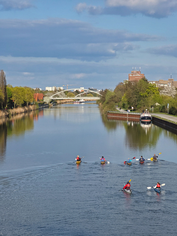 Hannover Niedersachsen Germany 14 April 2026 View of people kayaking on the canal with a bridge in the background under a blue sky.