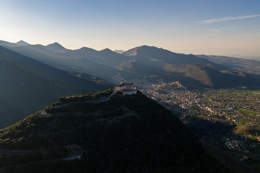 Aerial view of Santuario del Santissimo Salvatore on a hilltop overlooking the valley and surrounding mountains under a soft sunset light Montella Campania Italy. Aerial view of Santuario del Santissimo Salvatore on a hilltop overlooking the valley and surrounding mountains under a soft sunset light Montella Campania Italy.