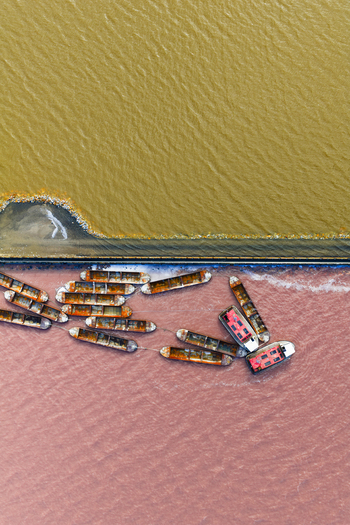 Aerial view of boats contrasting against the pink and yellow toned waters a surreal landscape capturing the essence of the salt flats San Pedro del Pinatar Spain. Aerial view of boats contrasting against the pink and yellow toned waters a surreal landscape capturing the essence of the salt flats San Pedro del Pinatar Spain.