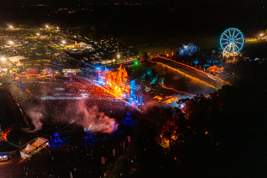 Herzogenaurach Germany 27 July 2025 Aerial view of Open Beatz Festival with an illuminated main stage a glowing ferris wheel and a large crowd of people at night. Herzogenaurach Germany 27 July 2025 Aerial view of Open Beatz Festival with an illuminated main stage a glowing ferris wheel and a large crowd of people at night.
