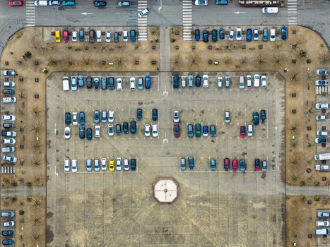 Aerial view of a parking lot filled with cars of many colours surrounded by roads and sidewalks Neuf Brisach Grand Est France.