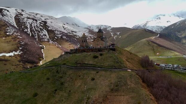 Aerial view of Gergeti Trinity Church and snow capped mountains Georgia.