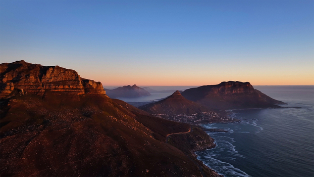 Aerial view of the rugged peaks of Table Mountain and Lion s Head overlooking the Atlantic coastline during a golden sunset in Cape Town Western Cape South Africa. Aerial view of the rugged peaks of Table Mountain and Lion s Head overlooking the Atlantic coastline during a golden sunset in Cape Town Western Cape South Africa.