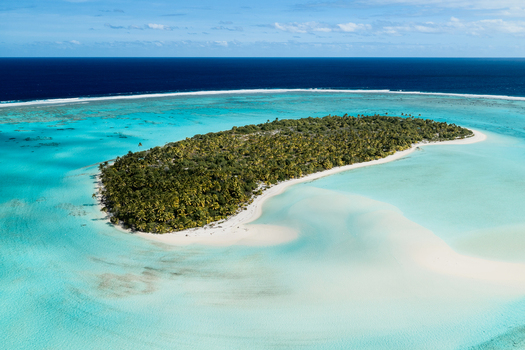 Aerial view of Aitutaki island surrounded by a turquoise lagoon and white sandy beaches in the Cook Islands. Aerial view of Aitutaki island surrounded by a turquoise lagoon and white sandy beaches in the Cook Islands.