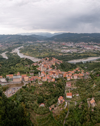 Aerial view of the historic hilltop village with its characteristic terracotta rooftops surrounded by lush green hills and a river valley in Vezzano Ligure Liguria Italy.