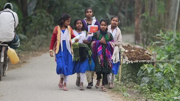 View of schoolgirls walking on a rural road in Bogura Bangladesh.