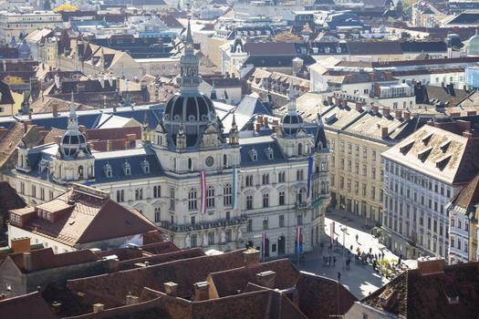 View of the opulent city hall stands at the Hauptplatz main square amidst a sea of terracotta rooftops its ornate facade adorned with flags a symphony of architectural styles Graz Styria Austria. View of the opulent city hall stands at the Hauptplatz main square amidst a sea of terracotta rooftops its ornate facade adorned with flags a symphony of architectural styles Graz Styria Austria.
