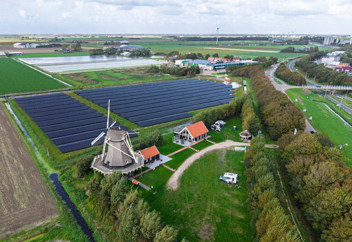 Aerial view of Molen De Hoop windmill situated next to a large solar panel field and green landscape in t Zand North Holland Netherlands. Aerial view of Molen De Hoop windmill situated next to a large solar panel field and green landscape in t Zand North Holland Netherlands.