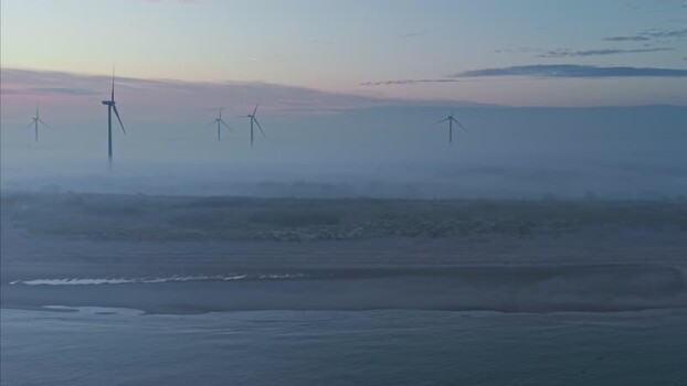 Aerial view of wind turbines in the fog over the coast Netherlands. Aerial view of wind turbines in the fog over the coast Netherlands.