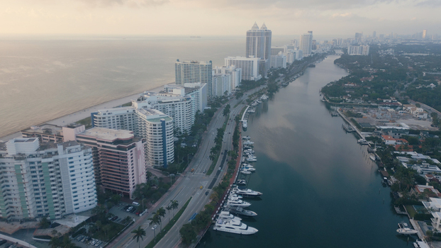 Aerial view of the Miami Beach skyline featuring high rise buildings a scenic coastline and a calm waterway filled with luxury yachts in Miami Beach Florida United States. Aerial view of the Miami Beach skyline featuring high rise buildings a scenic coastline and a calm waterway filled with luxury yachts in Miami Beach Florida United States.