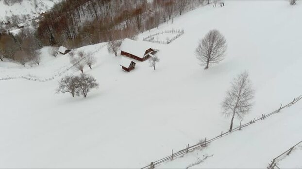 Aerial view of a wooden house in a snowy field Romania. Aerial view of a wooden house in a snowy field Romania.