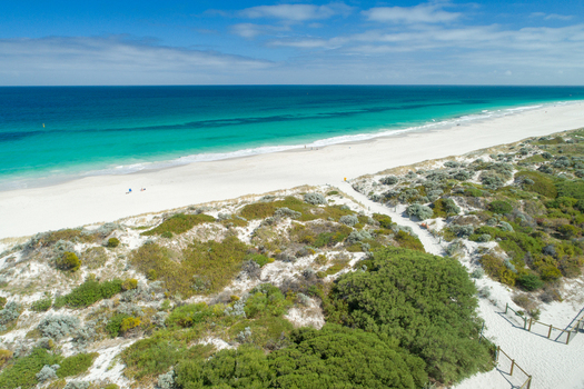 Aerial view of a pristine beach with turquoise water white sand and coastal vegetation under a clear blue sky in Perth Western Australia Australia. Aerial view of a pristine beach with turquoise water white sand and coastal vegetation under a clear blue sky in Perth Western Australia Australia.