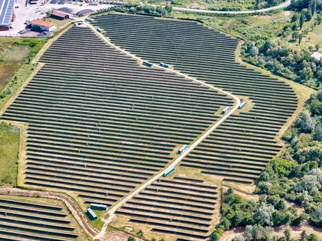 Aerial view of a large solar farm with rows of photovoltaic panels surrounded by green fields and trees in Torrazza Piemonte Piemonte Italy. Aerial view of a large solar farm with rows of photovoltaic panels surrounded by green fields and trees in Torrazza Piemonte Piemonte Italy.