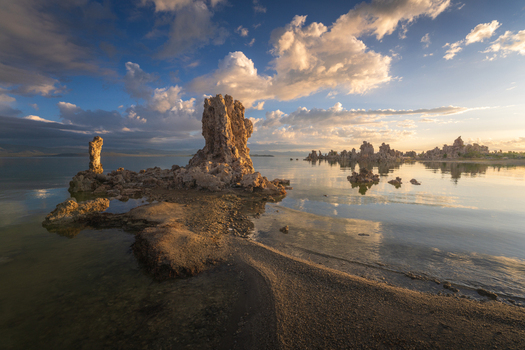 Aerial view of Mono Lake featuring unique tufa towers rising from the calm water under a dramatic sunset sky with golden clouds Mono County California United States. Aerial view of Mono Lake featuring unique tufa towers rising from the calm water under a dramatic sunset sky with golden clouds Mono County California United States.